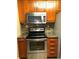 Galley kitchen featuring stainless steel oven, microwave, and stylish backsplash at 105 S Obrien St # 216, Tampa, FL 33609