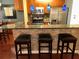 Kitchen area with wooden cabinets, stainless steel appliances, and black leather bar stools at 105 S Obrien St # 216, Tampa, FL 33609