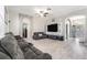 Open-concept living room with wood flooring, neutral walls, a large television, and a view of the front entry at 11450 Cypress Park St, Tampa, FL 33624