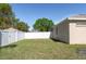 A partially shaded backyard, enclosed by a white fence, offers privacy and space for outdoor activities at 11749 Summer Springs Dr, Riverview, FL 33579
