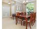 Formal dining area with a large window letting in natural light and a classic chandelier at 11749 Summer Springs Dr, Riverview, FL 33579