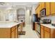 Galley-style kitchen featuring stainless steel appliances, light wood cabinets, and white countertops at 11749 Summer Springs Dr, Riverview, FL 33579