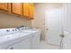 Bright laundry room with cabinets above the washer and dryer and door to the right at 11749 Summer Springs Dr, Riverview, FL 33579