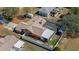 A high angle aerial view of a house with a screened pool, fenced yard, and shed on a sunny day at 12256 Katherwood St, Spring Hill, FL 34608