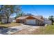 Cozy single-story home featuring a stone-accented facade and a large, attached two-car garage with long driveway at 12256 Katherwood St, Spring Hill, FL 34608