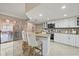 Bright kitchen features granite countertops, white cabinetry, stainless steel appliances, and breakfast bar seating at 12256 Katherwood St, Spring Hill, FL 34608