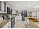 Open kitchen featuring granite countertops, white cabinetry, stainless steel appliances, and adjacent dining area at 12256 Katherwood St, Spring Hill, FL 34608