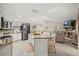Open kitchen with a center island, granite countertops, white cabinetry, stainless steel appliances, and barstool seating at 12256 Katherwood St, Spring Hill, FL 34608
