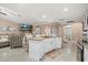 Open kitchen with a center island, breakfast bar, granite countertops, white cabinetry, and stainless steel appliances at 12256 Katherwood St, Spring Hill, FL 34608