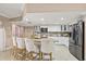 Open kitchen featuring granite countertops, white cabinetry, stainless steel appliances, and breakfast bar seating at 12256 Katherwood St, Spring Hill, FL 34608