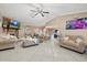 Bright living room features a fireplace, tile floors, plush seating, and an open layout with the kitchen at 12256 Katherwood St, Spring Hill, FL 34608