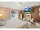 This main bedroom features a flatscreen television, gold decor, and a view of the pool at 12256 Katherwood St, Spring Hill, FL 34608