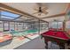 Inviting screened pool area with a pool table, fans and comfortable seating for relaxing and entertaining at 12256 Katherwood St, Spring Hill, FL 34608