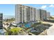 Beautiful high-rise condo with a beach view and a pool surrounded by palm trees on a sunny day at 1270 Gulf Blvd # 905, Clearwater Beach, FL 33767