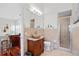 Bathroom featuring a carved vanity, standalone sink, walk-in shower and views into other rooms at 1314 Jumana Loop, Apollo Beach, FL 33572