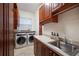 Functional laundry room with modern appliances, cabinets, and a window at 1314 Jumana Loop, Apollo Beach, FL 33572