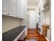 Home office featuring white cabinets, shelving, hardwood floors, and a long desk at 1314 Jumana Loop, Apollo Beach, FL 33572