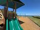 Community playground equipment including a slide and swings, adjacent to the water with nice green lawn at 1314 Jumana Loop, Apollo Beach, FL 33572