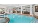 Indoor pool features a swim-up bar, hot tub, tile floor, and white pillars throughout the indoor pool area at 1314 Jumana Loop, Apollo Beach, FL 33572