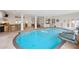 Bright indoor pool and spa features an adjacent bar and multiple doorways to outdoor areas at 1314 Jumana Loop, Apollo Beach, FL 33572