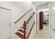 Interior stairway with white walls, natural wood stairs and banister, and tile flooring at 1314 Jumana Loop, Apollo Beach, FL 33572