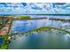Attractive aerial view of waterfront property with multiple boat docks and an adjacent lake with lush green landscaping at 140 Riviera Dunes Way # 404, Palmetto, FL 34221