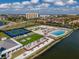 Aerial view of resort featuring a pool, tennis courts, and beautiful landscaping overlooking a lake at 140 Riviera Dunes Way # 404, Palmetto, FL 34221