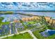 Attractive aerial view showcasing waterfront condos with boat docks, a tennis court, and meticulously manicured landscaping at 140 Riviera Dunes Way # 404, Palmetto, FL 34221