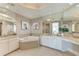 Large bathroom with tub, dual sinks, white cabinets and marble countertops at 140 Riviera Dunes Way # 404, Palmetto, FL 34221