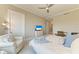 Cozy bedroom featuring a ceiling fan, a comfortable armchair, and neutral decor at 140 Riviera Dunes Way # 404, Palmetto, FL 34221
