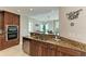 Kitchen with wood cabinets, granite countertops and stainless steel appliances near the dining area at 140 Riviera Dunes Way # 404, Palmetto, FL 34221