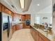 Spacious kitchen with wood cabinetry, granite countertops, and stainless steel appliances at 140 Riviera Dunes Way # 404, Palmetto, FL 34221