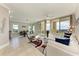 Bright living room with tile floors, modern furnishings, and sliding glass doors leading to a balcony with a view at 140 Riviera Dunes Way # 404, Palmetto, FL 34221