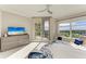 Bright main bedroom features a ceiling fan, balcony access, and a large window with scenic views at 140 Riviera Dunes Way # 404, Palmetto, FL 34221