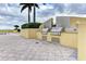 A built-in outdoor kitchen features modern appliances and ample counter space for entertaining by the pool at 140 Riviera Dunes Way # 404, Palmetto, FL 34221