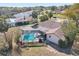 Aerial view of a home with a screened-in pool, lush green backyard, and a well-maintained lawn at 14048 Bruni Dr, Spring Hill, FL 34609