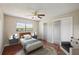Brightly lit bedroom with a ceiling fan, a pair of closets, and a large picture window at 14048 Bruni Dr, Spring Hill, FL 34609