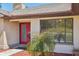 Close up of home's front entry and red door, with a glimpse of the landscaped yard at 14048 Bruni Dr, Spring Hill, FL 34609