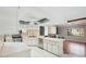 Bright kitchen with white cabinetry, stainless steel appliances, and an island bar overlooking the living room at 14048 Bruni Dr, Spring Hill, FL 34609