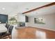 Bright living room features a brick fireplace, hardwood floors, and large windows with backyard view at 14048 Bruni Dr, Spring Hill, FL 34609