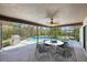 Staged view of screened patio with dining table, grill, view of the pool, and lush backyard at 14048 Bruni Dr, Spring Hill, FL 34609