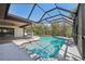 Screened-in pool with tile trim, adjacent to a covered patio with views of the lush backyard at 14048 Bruni Dr, Spring Hill, FL 34609