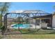 Screened-in pool and patio area with a lush green lawn and tropical trees offering privacy at 14048 Bruni Dr, Spring Hill, FL 34609