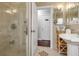 Well-lit bathroom with glass-door shower, unique pedestal sink, and decorative tile flooring at 16 N Saturn Ave, Clearwater, FL 33755