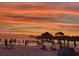 Picturesque sunset over the beach featuring the pier and silhouettes of people enjoying the serene coastal scene at 16 N Saturn Ave, Clearwater, FL 33755