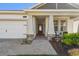 Inviting front porch featuring stately columns with stone accents, brick paver walkway and manicured landscaping at 19632 Fort King Run, Brooksville, FL 34601