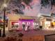 Charming ice cream storefront with lit trees, outdoor seating, and pink neon signage at twilight at 2041 Yale Ave, Dunedin, FL 34698