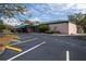 Large parking lot in front of commercial building with mature trees at 2312 Tudor Ln, Clearwater, FL 33763