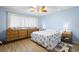 Bedroom with wood-look floors, rattan dressers, leaf fan, and light blue walls at 2379 Finlandia Ln # 21, Clearwater, FL 33763