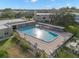 Aerial view of a large community pool with lounge chairs and manicured landscaping at 2379 Finlandia Ln # 21, Clearwater, FL 33763